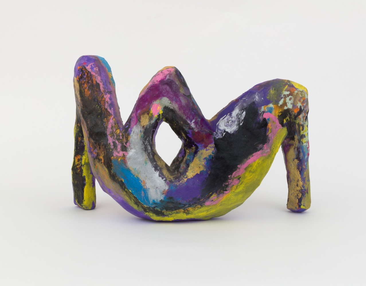 An abstract wood and papier maché sculpture with two bent leg like forms and an open triangular shape in the center.