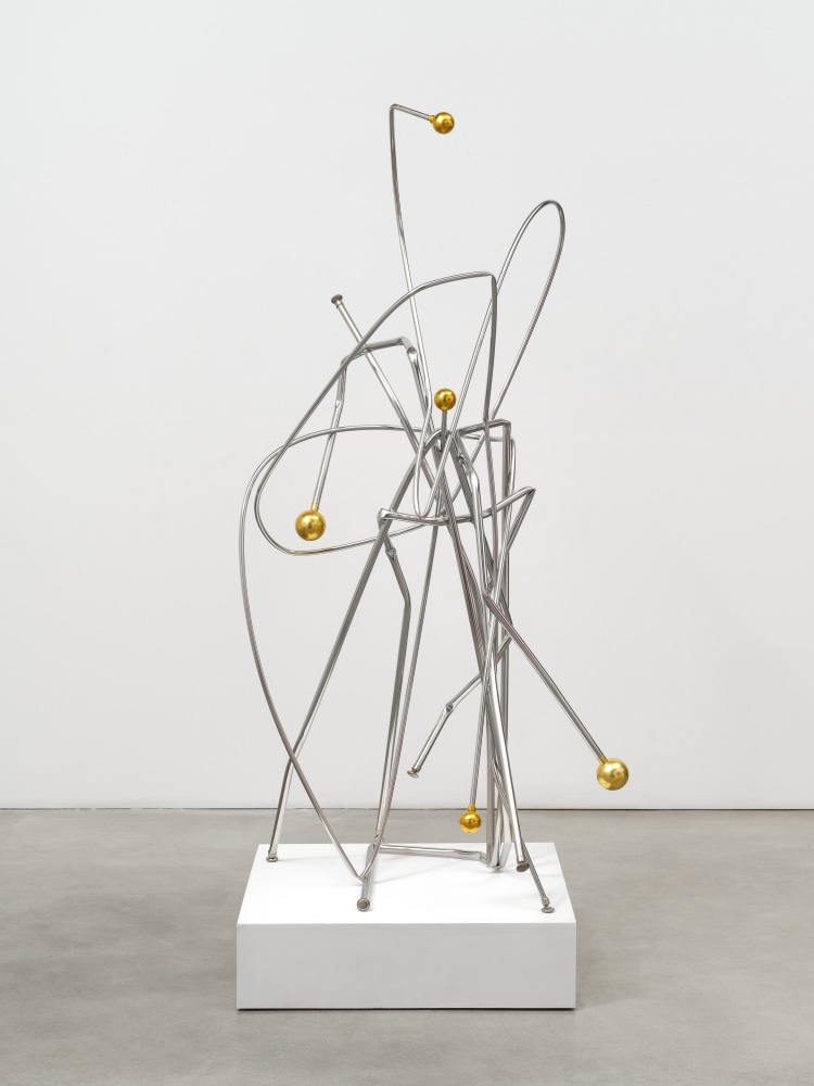 A steel sculpture by Josh Callaghan of twisted silver bars affixed with gold metal balls at the ends.