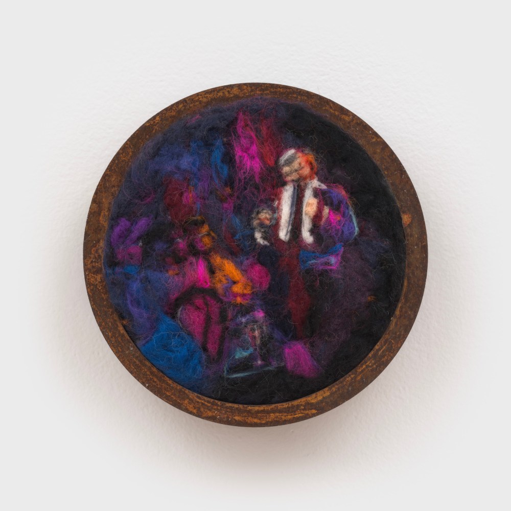 A wall mounted sculpture of raw felted wool depicting abstracted figures encircled in rusted steel.