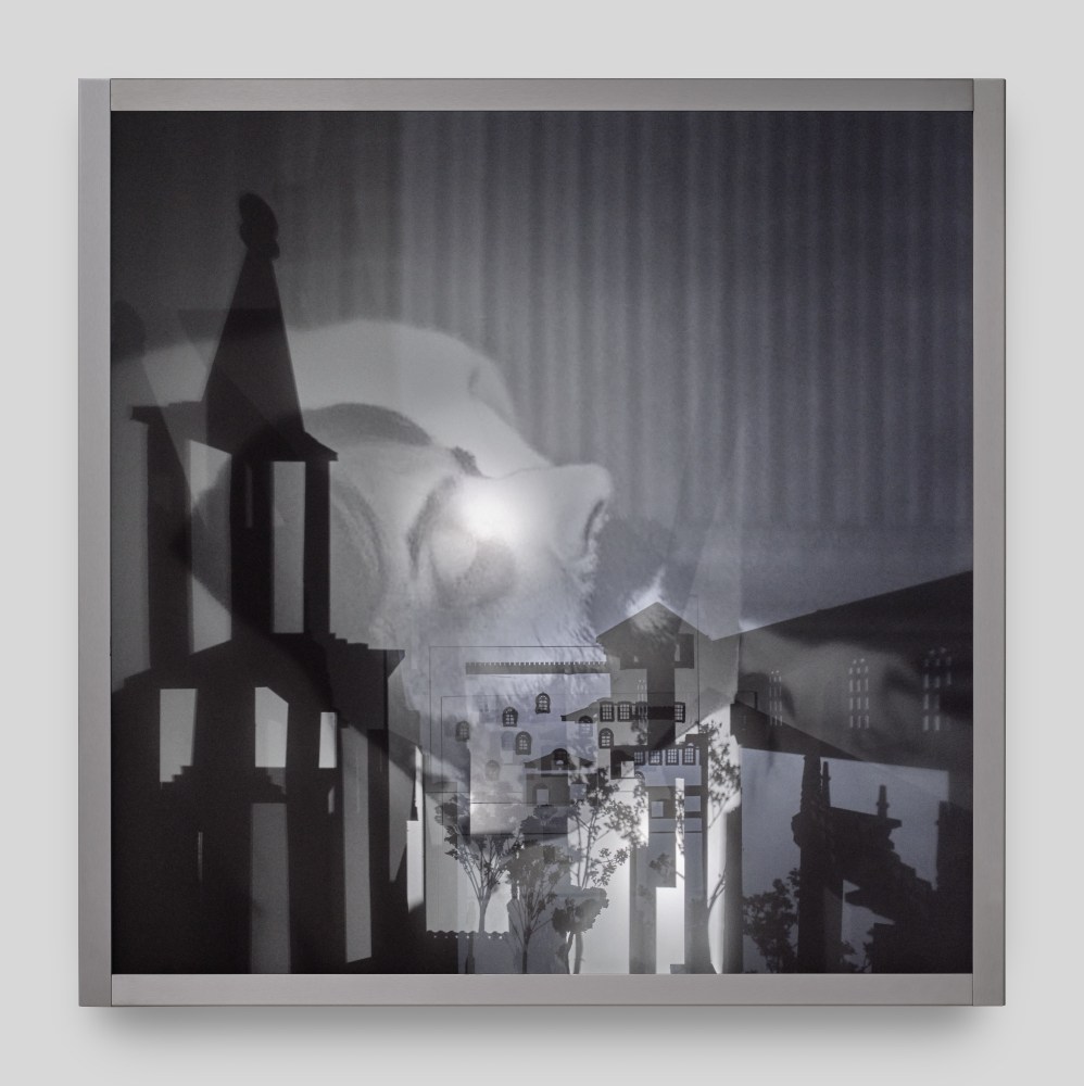 A wall mounted light box sculpture with moving projections of Marcel Proust on his death bed and shadows of steeples and trees.