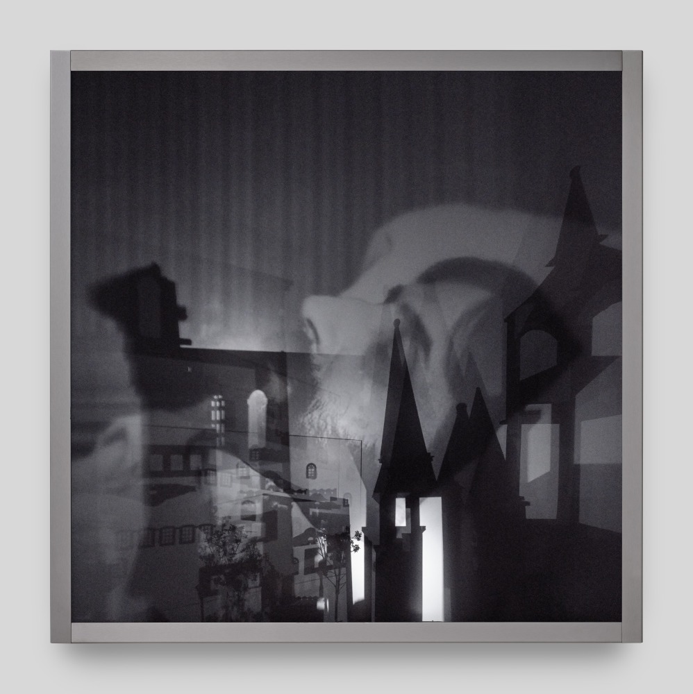 A wall mounted light box sculpture with moving projections of Marcel Proust on his death bed and shadows of steeples and trees.