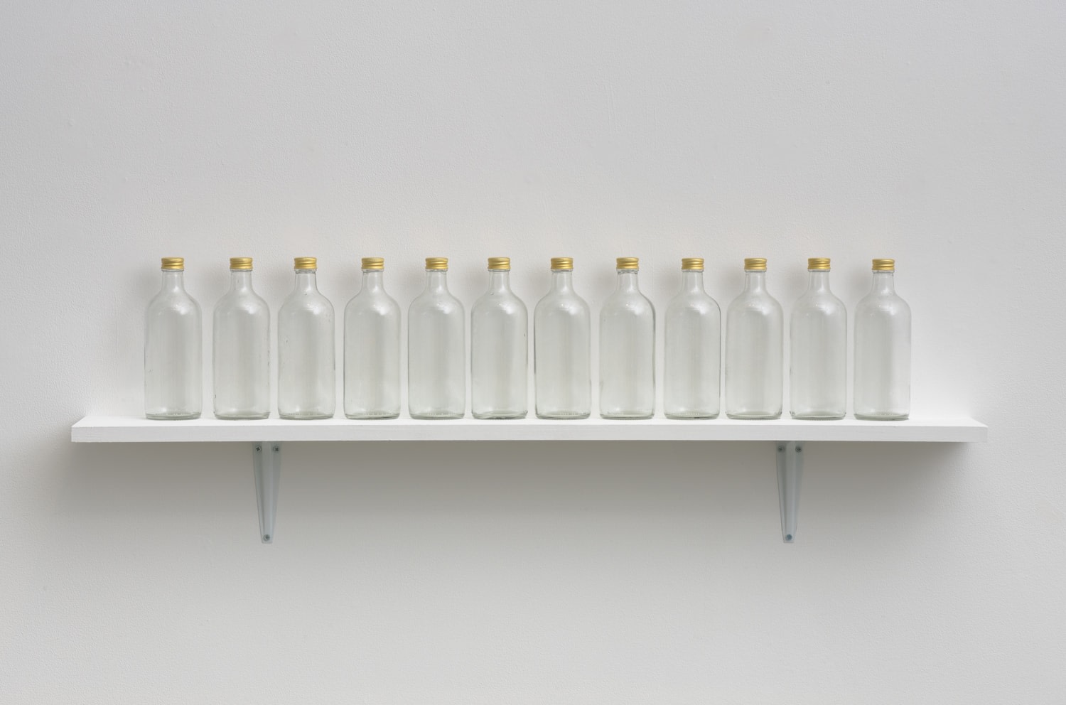 Untitled (Vapor Line), 2001-04
Twelve glass bottles, gold colored caps, water
8 x 44 x 3 inches,approximately