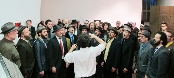Conductor guiding chorus of bearded men in top hats