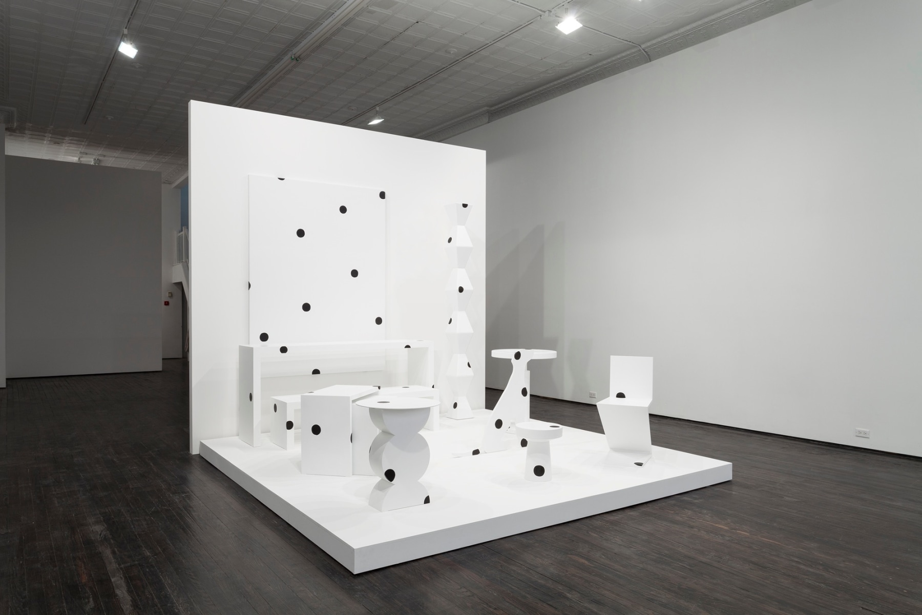 Side view of white abstract furniture, with black polka dots