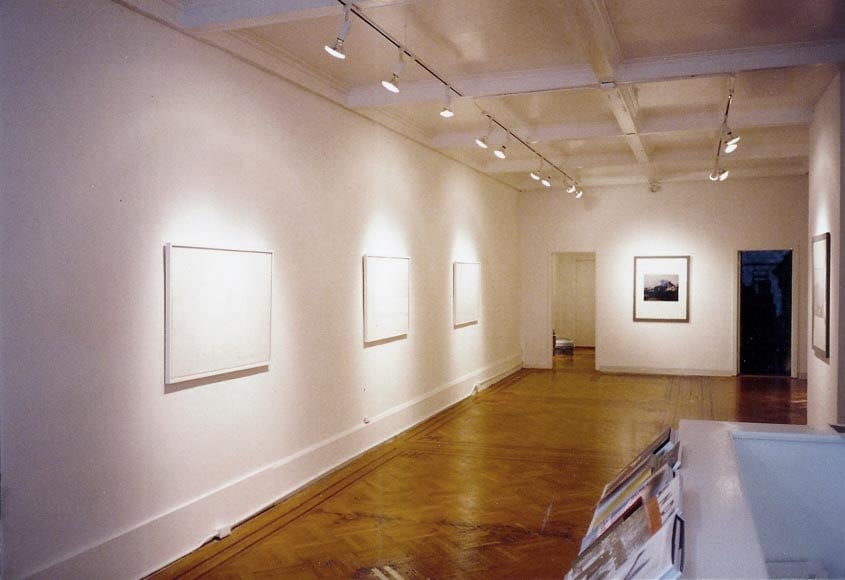 Installation view of blank canvases and black and white photos