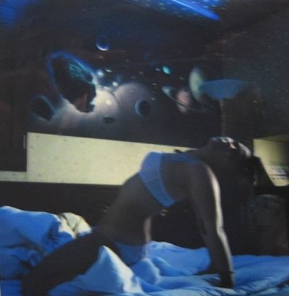 Still of woman in bed with planet decorations on ceiling