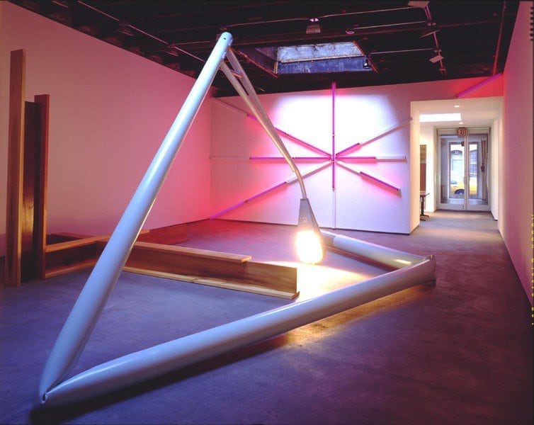 Art gallery installation of a sculpture show, with large, bent streetlight