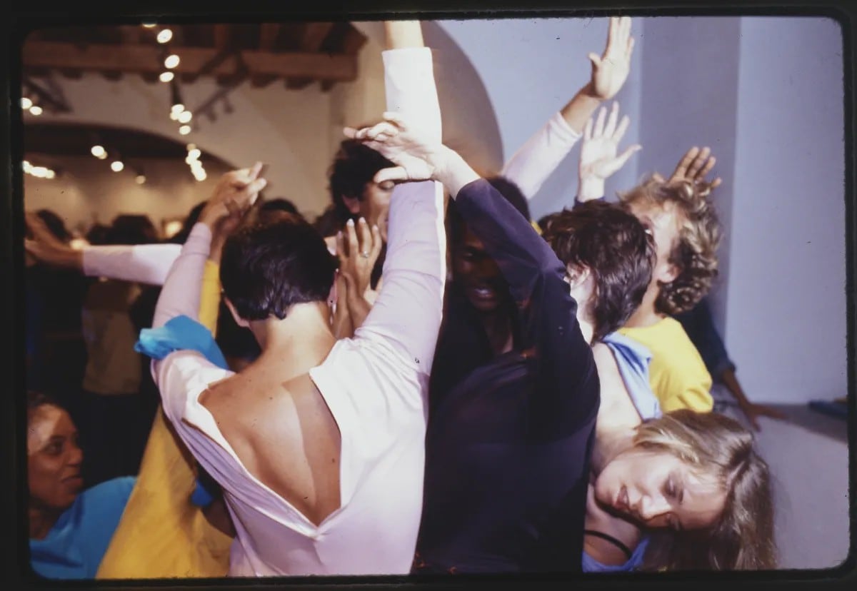 Close-up photograph of 7 dancers in various colored leotards