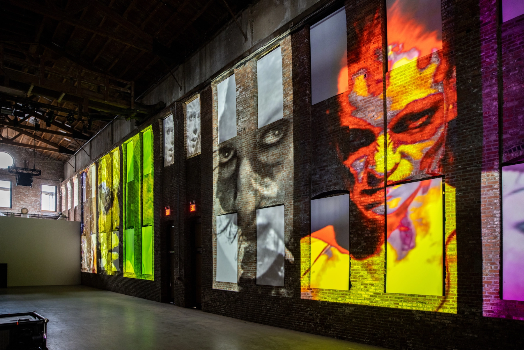 video projection of faces on a brick wall