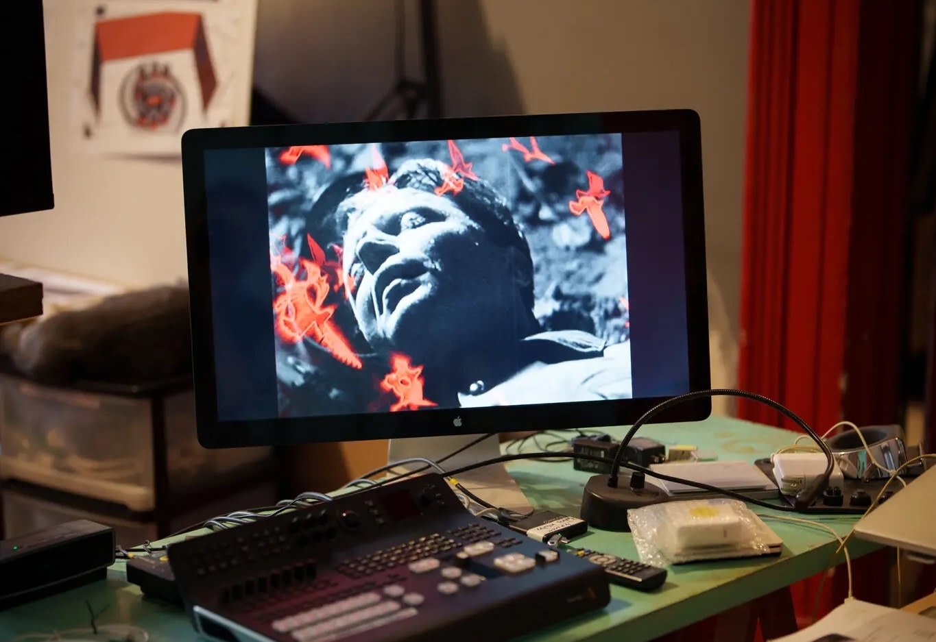 A desk with monitor and video editing equipment in an artist's studio