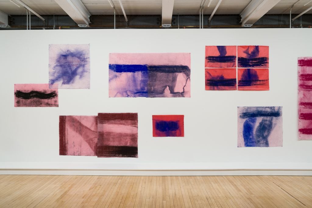 Wall of abstract paintings on paper, red and blue