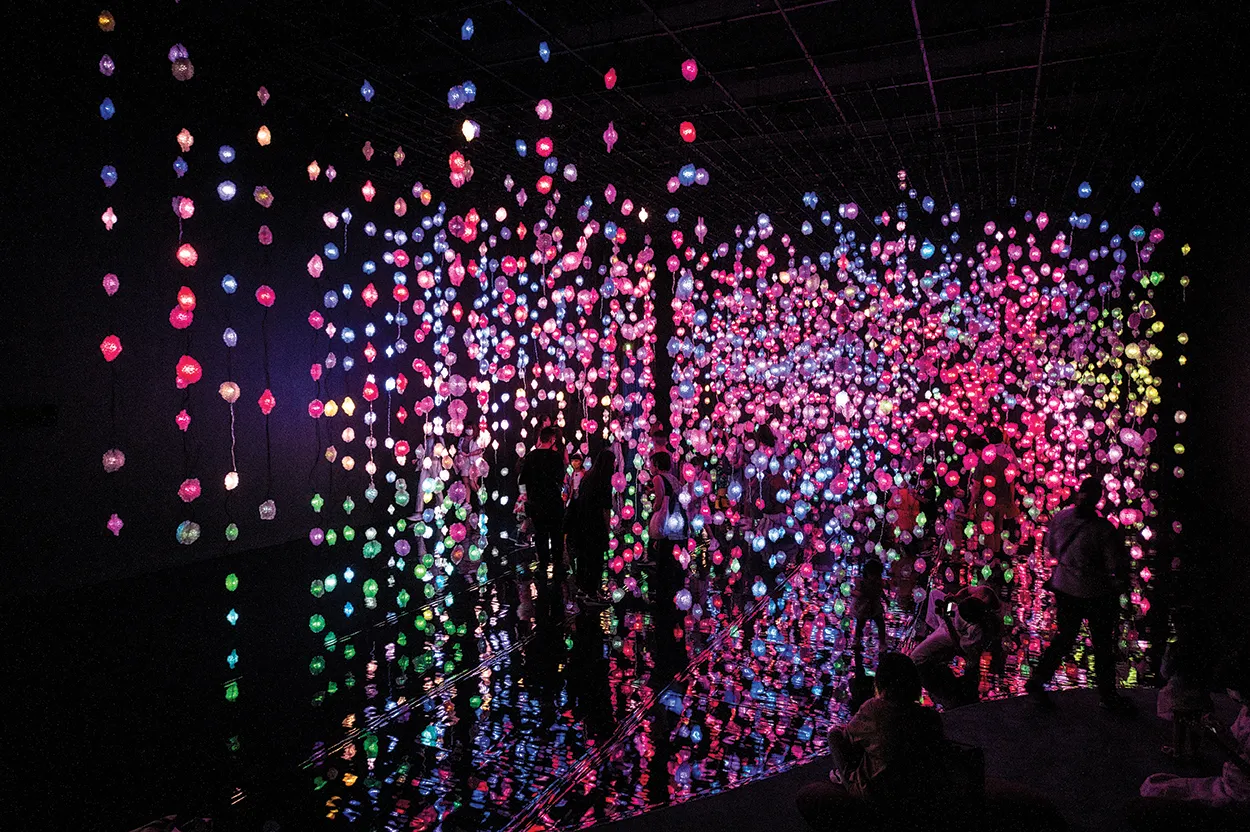 multicolored light strings hanging vertically in a darkened room