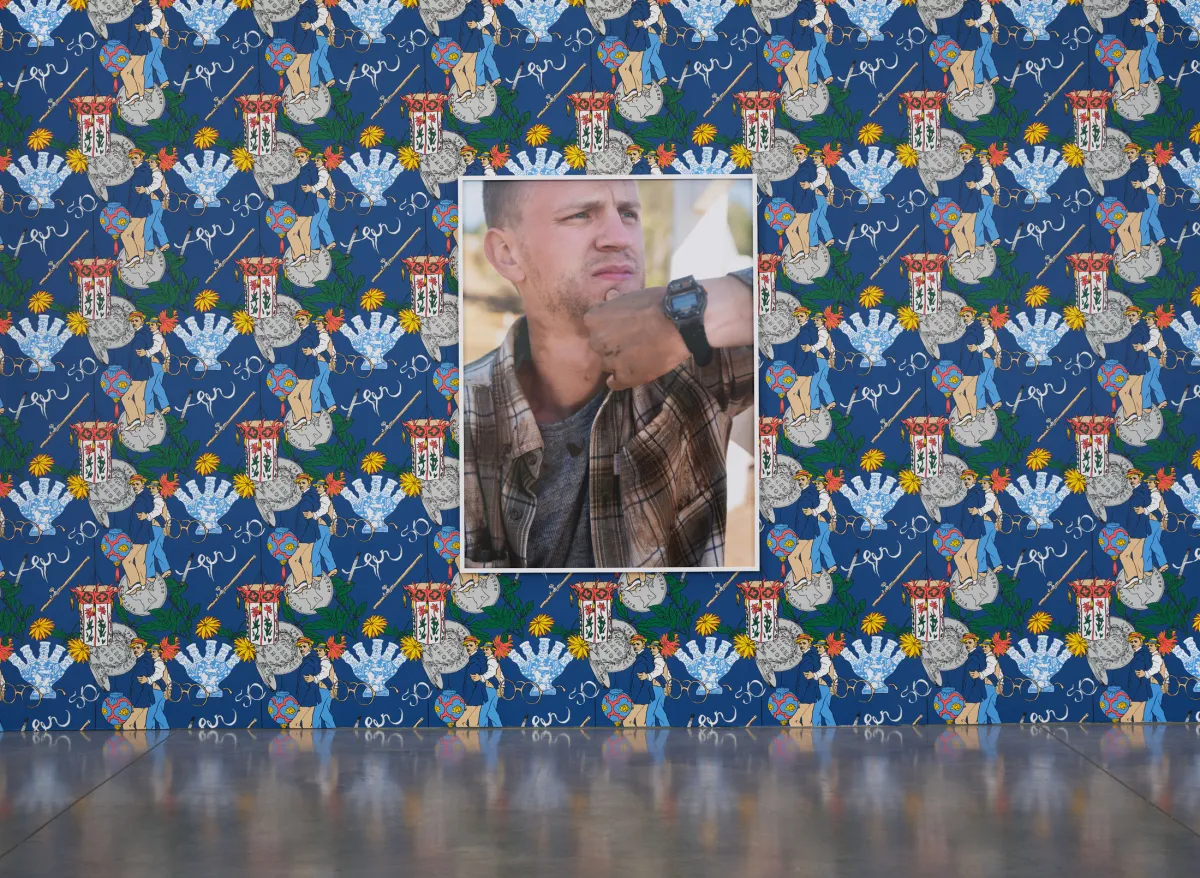 Large photograph of a white man on patterned blue wallpaper