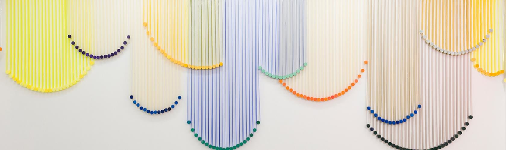 Vertical ribbons installed on wall as artwork