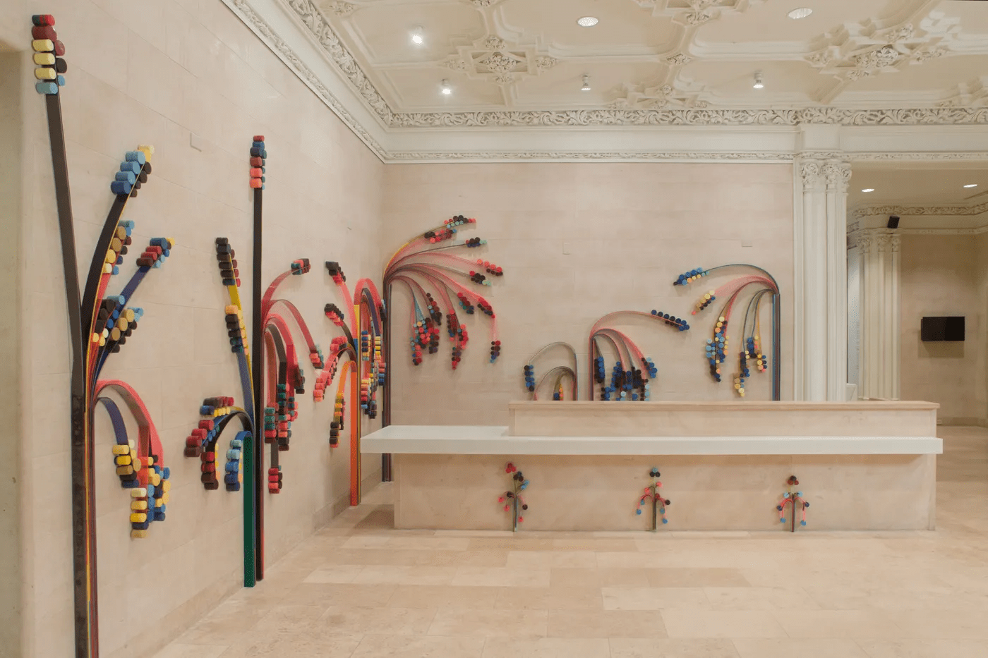 Art gallery installation of multi-colored materials that look similar to geometric trees