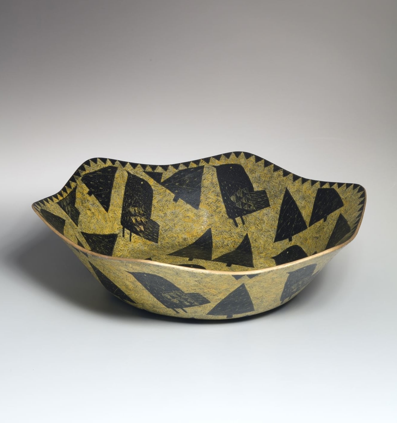 Large, hexagonal foliated bowl with black bird pattern set against a lemon yellow ground, 1999