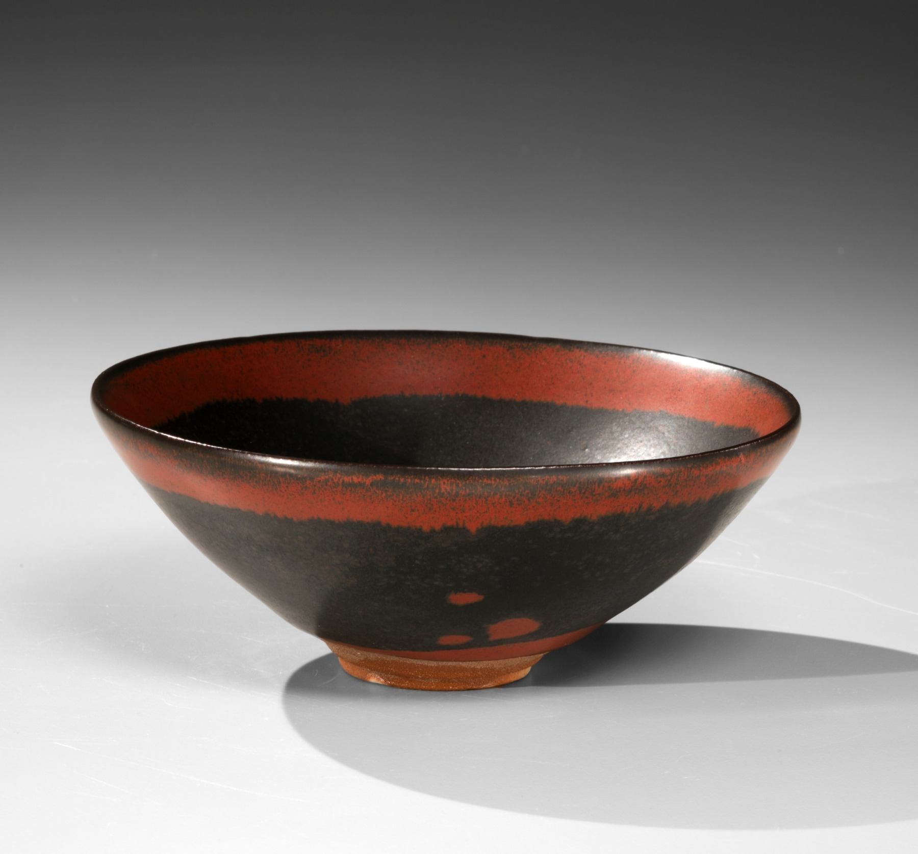 Black bowl with red band around the rim and dot in the interior, ca. 2004