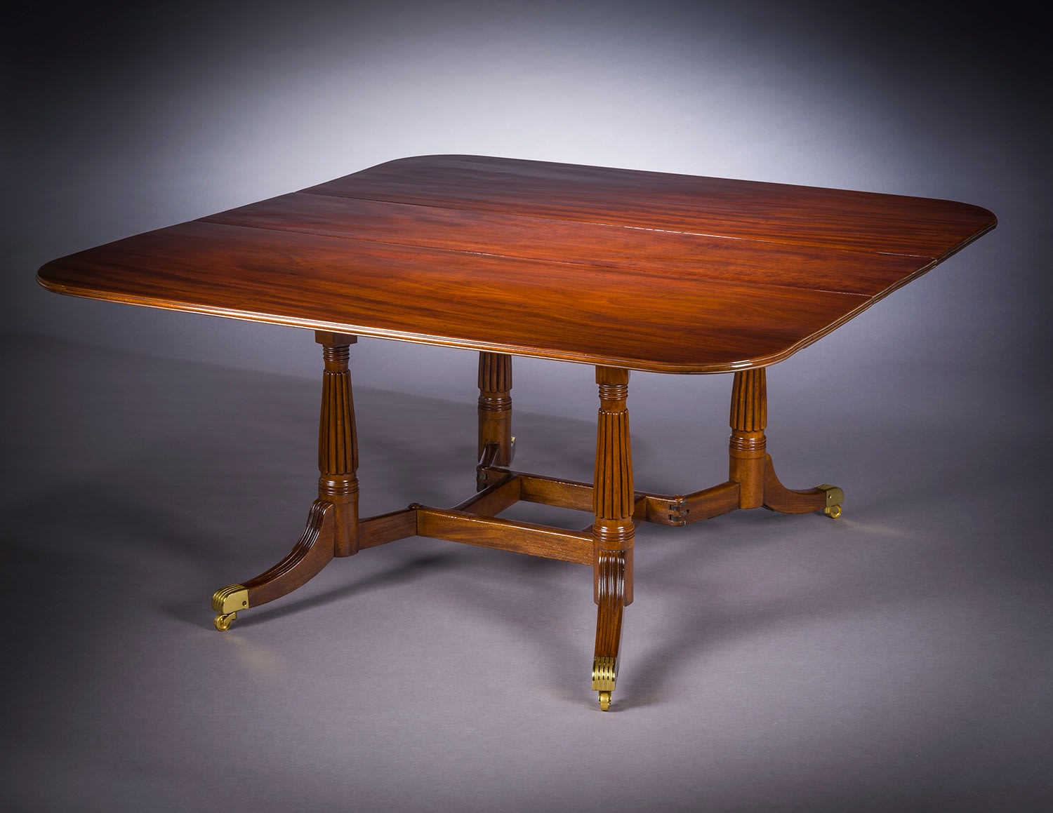 Cumberland-action Dining Table, about 1815&ndash;20. Attributed to Thomas Seymour, possibly for Isaac Vose, Boston. Mahogany, with gilt brass toe-caps and castors 28 3/4 in. high, 62 1/4 in. long, 60 in. wide; with leaves down, 17 in. wide, 62 1/4 in. long