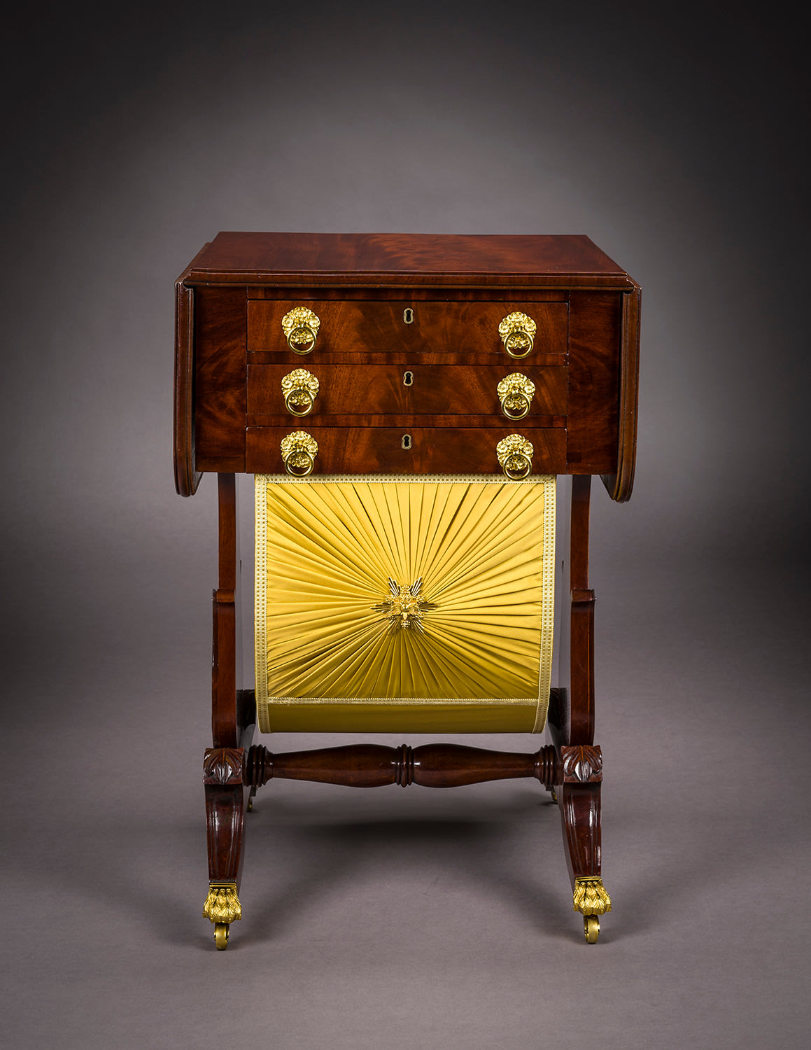Neo-Classical Drop-Leaf Work Table with Lyre Ends, about 1828&ndash;29. Attributed to Rufus Pierce, Boston. Mahogany, with gilt-brass paw toe-caps and castors, drawer pulls, key-hole escutcheons, baize writing surface, and fabric on workbox, 28 13/16 in. high, 19 1/2 in. wide, 20 1/8 in. deep (at the castors). Frontal view.