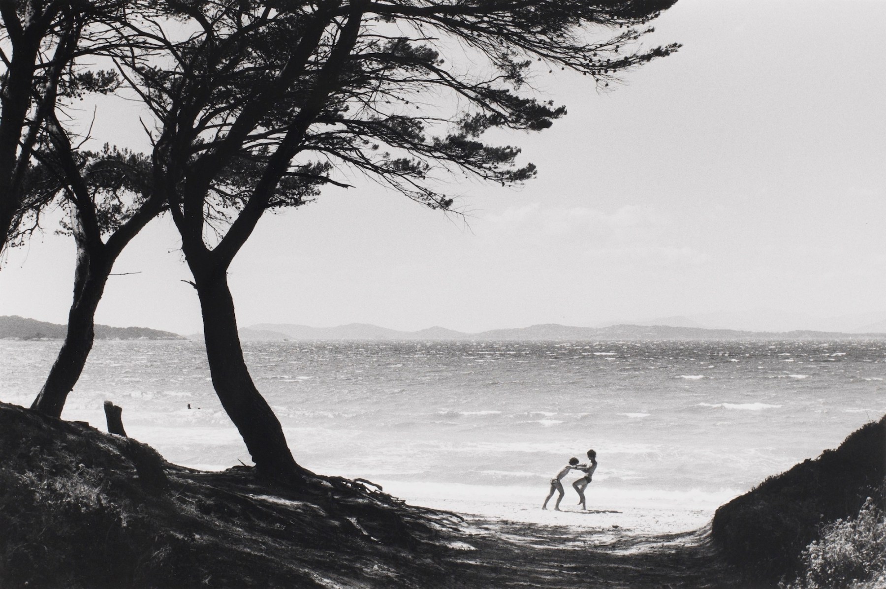 Bernard Plossu (1945-)  Untitled (Playing on beach, two trees), n.d.  Gelatin silver print  12 x 16 inches (paper), black and white photography black and white photography