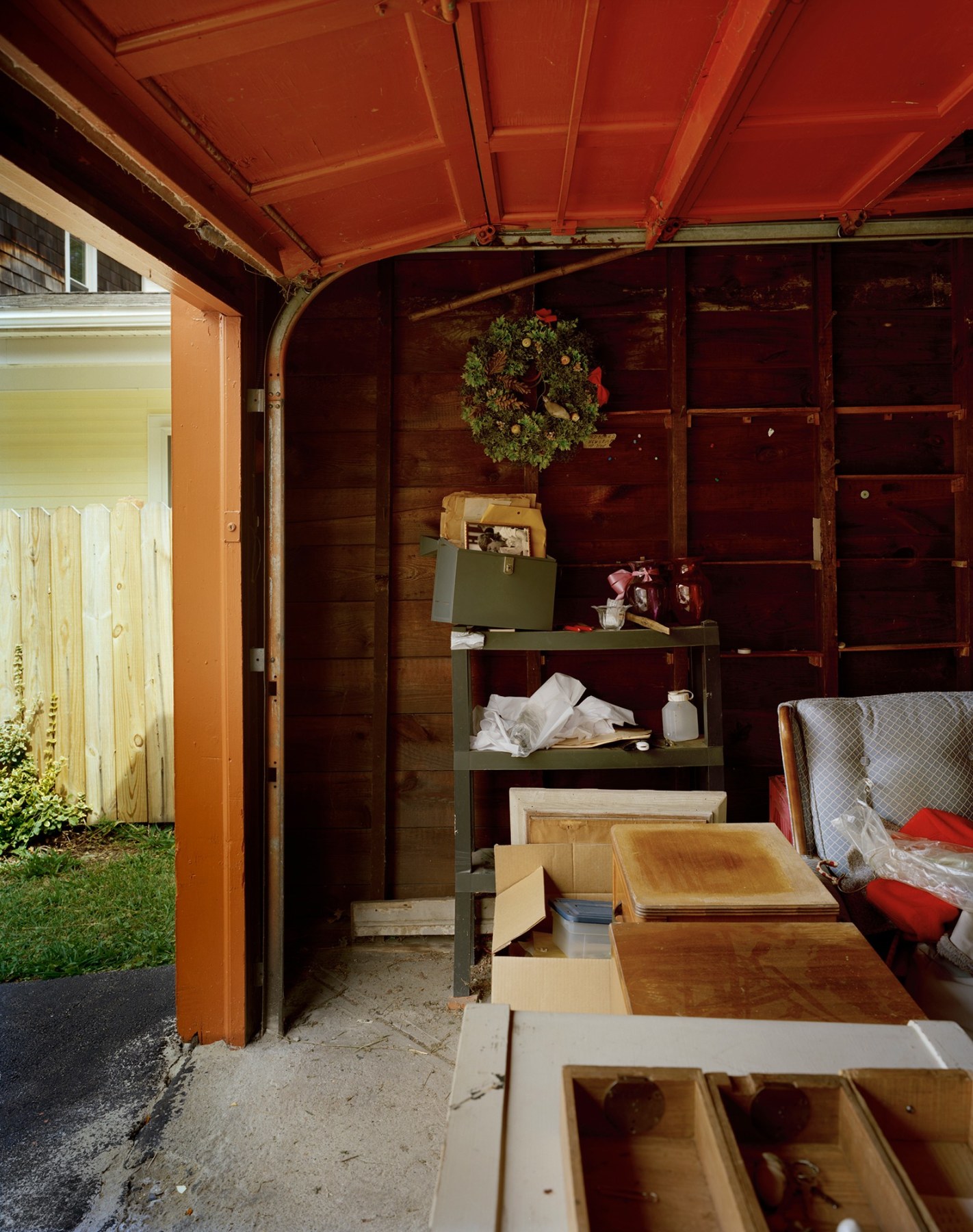 Color photograph of garage with rolling door open, by Jade Doskow