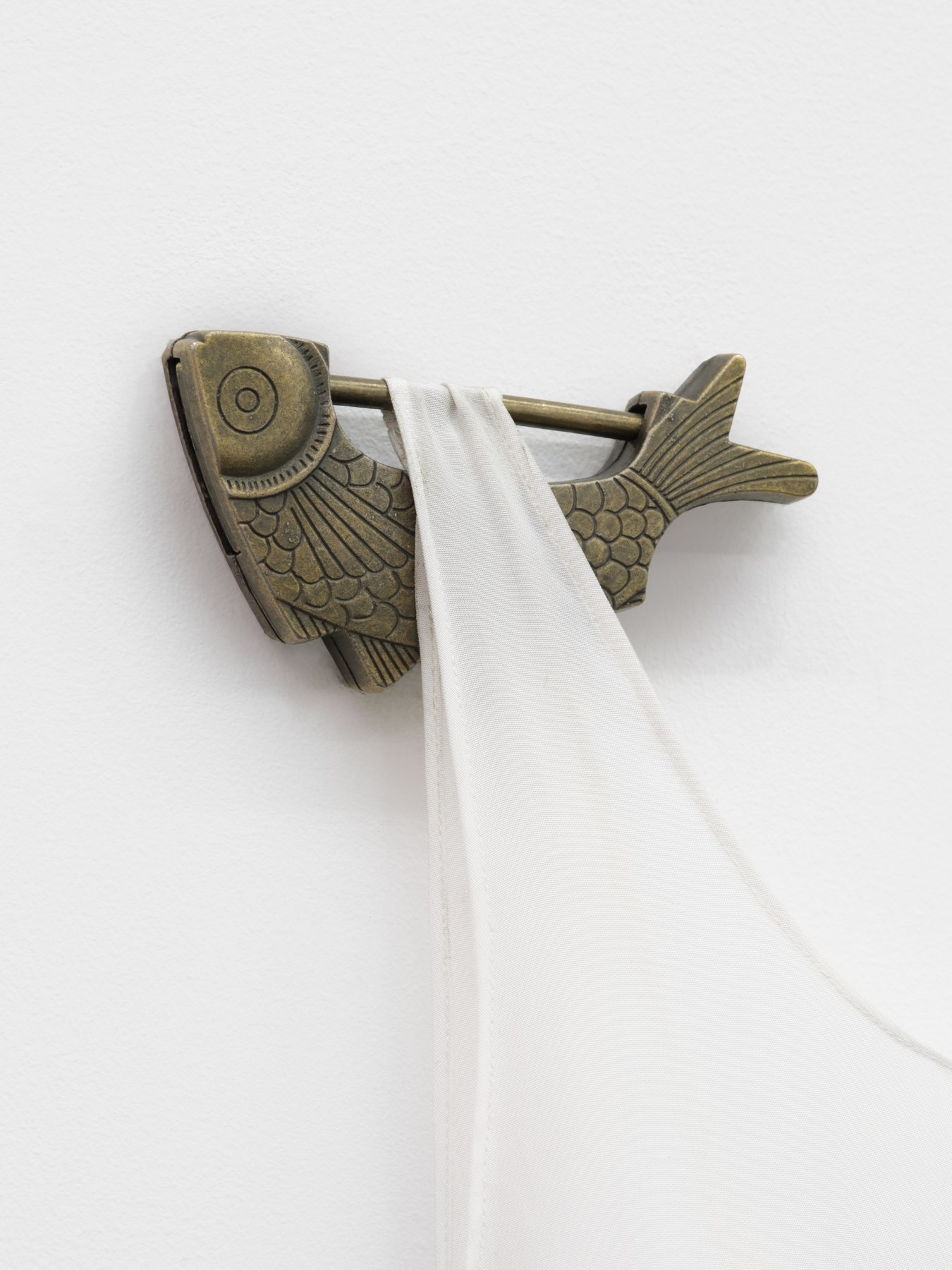 Detail of a sculpture by Rachel Youn titled "The Nature of Love," 2023, featuring a vibration platform machine, steel, an artificial plant, hanbok sokchima, and brass padlocks