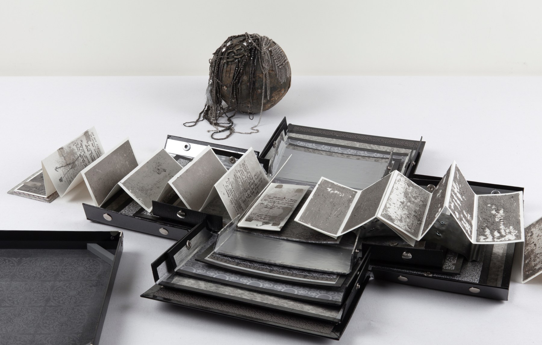 Silver, 2011 Aged silver metallic paper, paper, lead, necklaces, chain, bell, trinkets, one leporello book