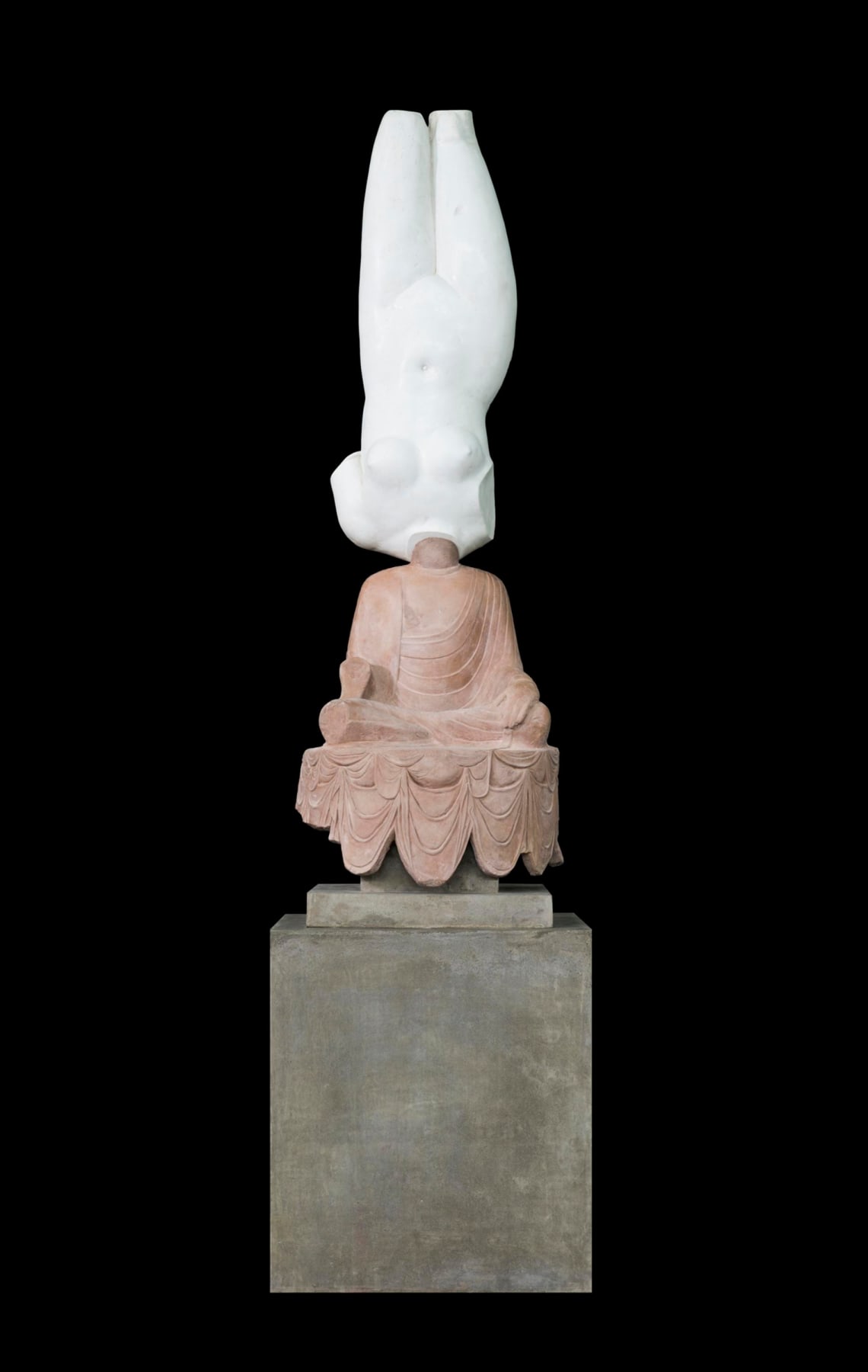Greek marble sculpture upside down connected to the statue of a Buddha via the neck