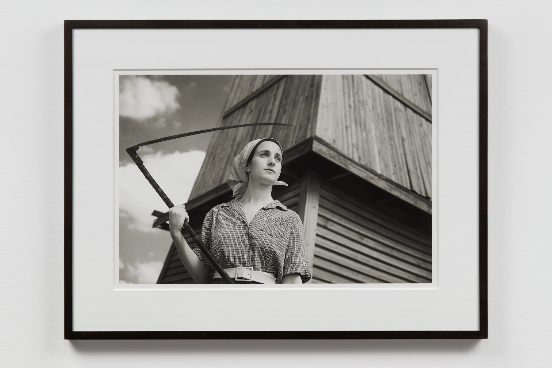 grayscale photograph of a woman holding a scythe