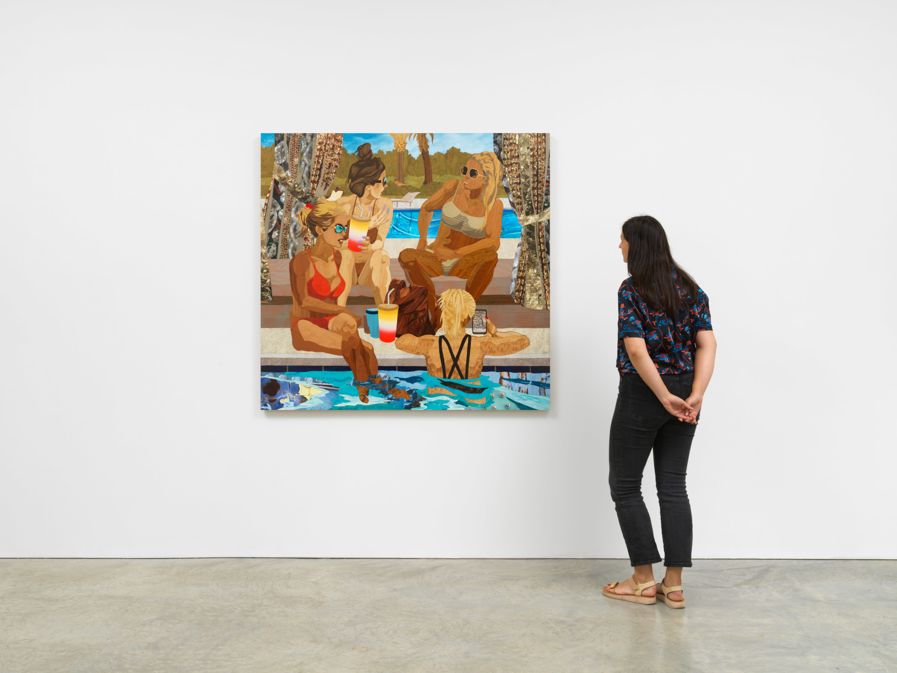 woman looking at an artwork depicting women in bathing suits lounging at a pool