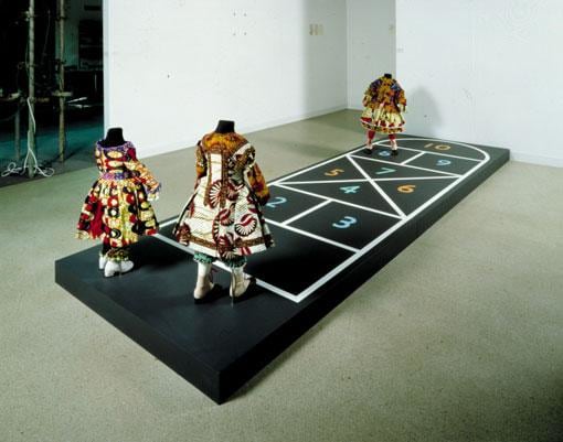 headless mannequins wearing intricate clothing playing hopscotch