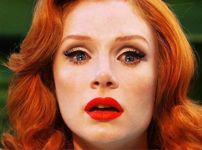 woman with watery eyes, red lipstick, and red hair
