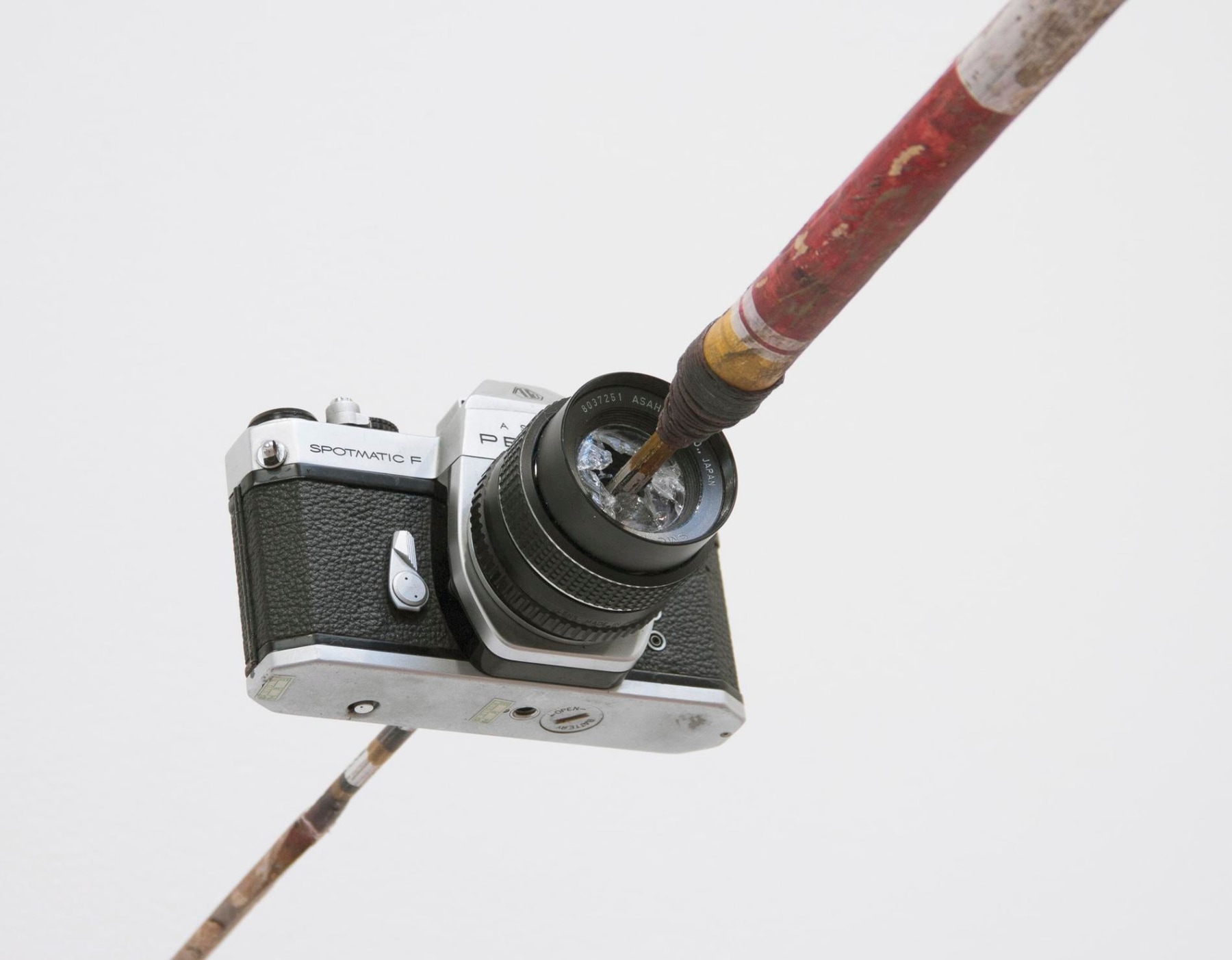 An aboriginal spear piercing the lens of a camera