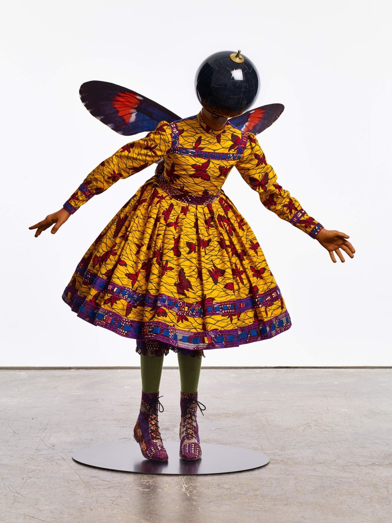 mannequin with a globe for a head with butterfly wings