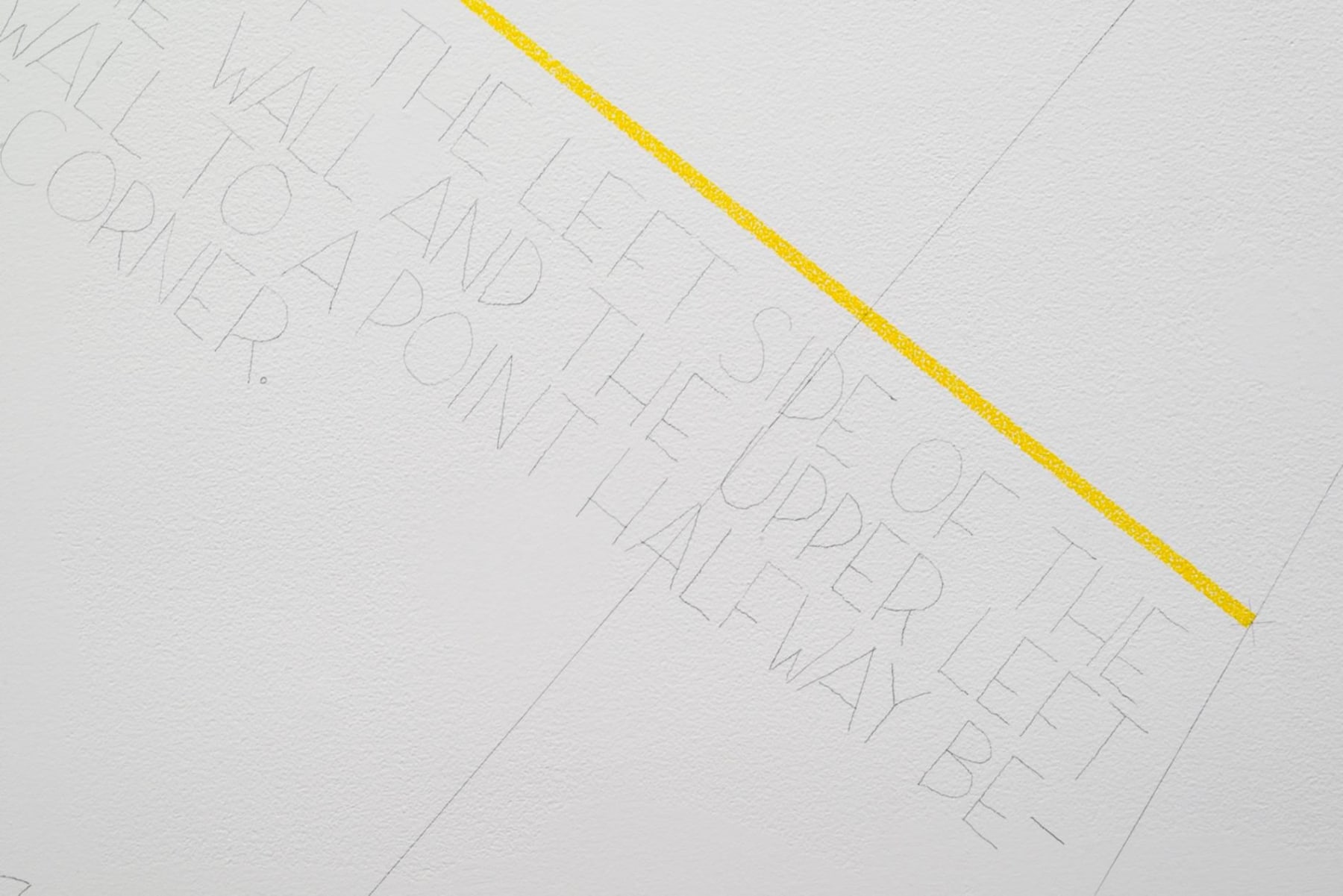 yellow line with text underneath it drawn directly on the wall