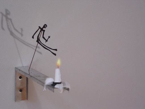 stick figure hanging over a lit candle