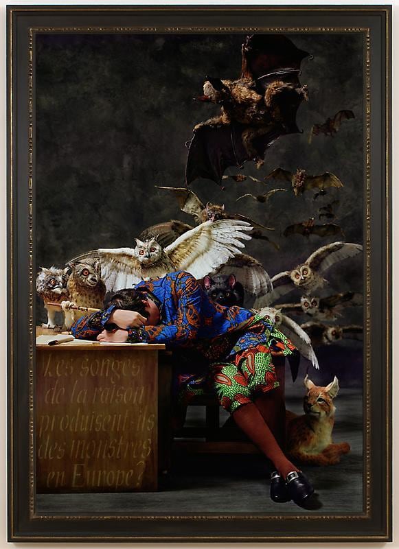white man asleep on his desk with several animals behind him