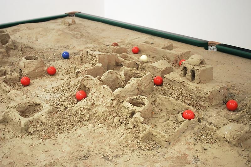 blue, red and white balls scattered across a sand sculpture