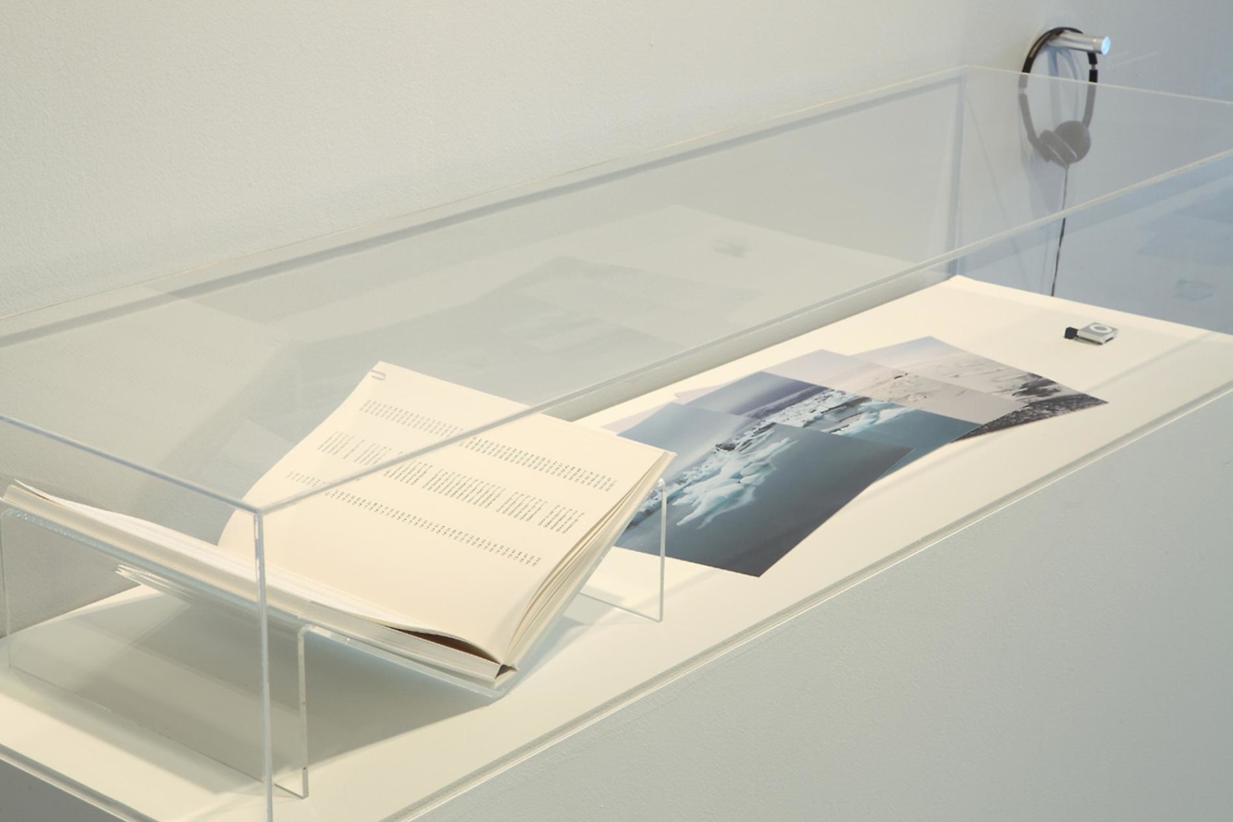an open book and a series of images encased on a pedestal