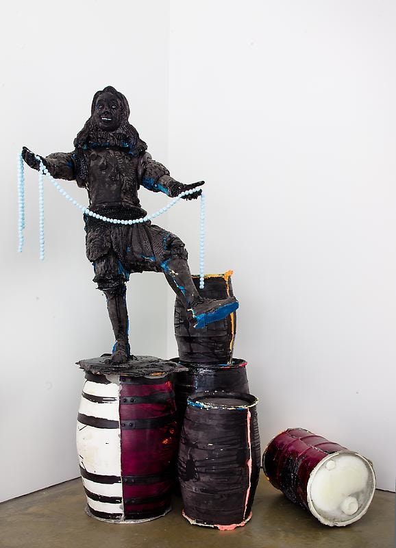 black figure standing on black barrels