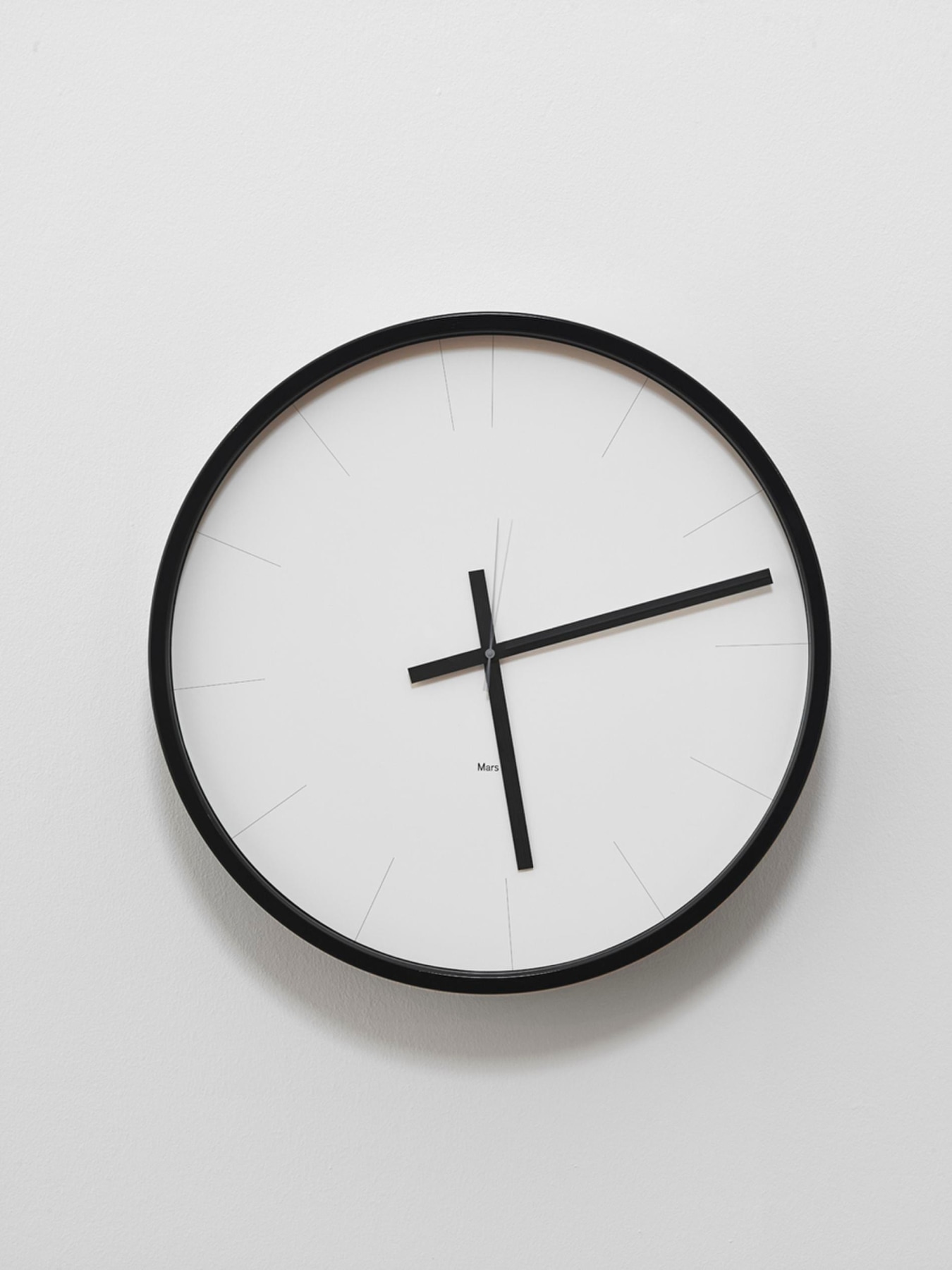 image of a clock hanging on a white wall