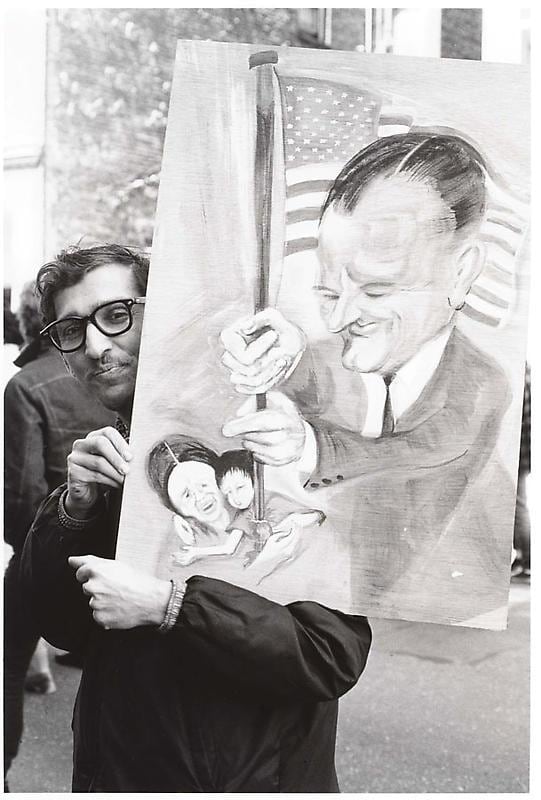man holding up a caricature of the president