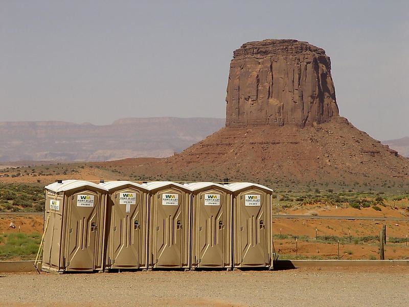 port-a-potties lined up in front of a mesa