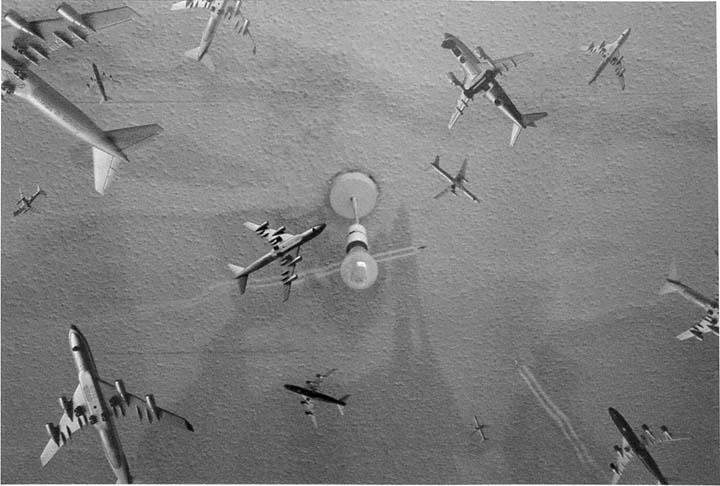 miniature airplanes flying around a room; a hanging lightbulb is centered in the image