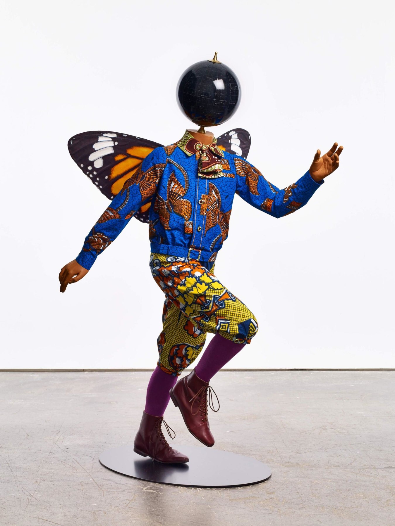 mannequin with a globe for a head and butterfly wings skipping