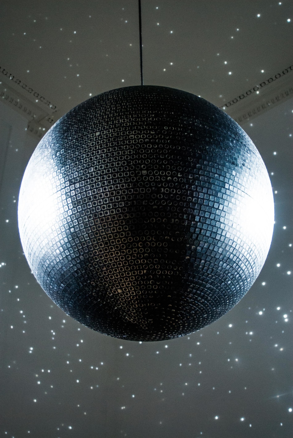 image of a disco ball lighting up a dark room with specks of light