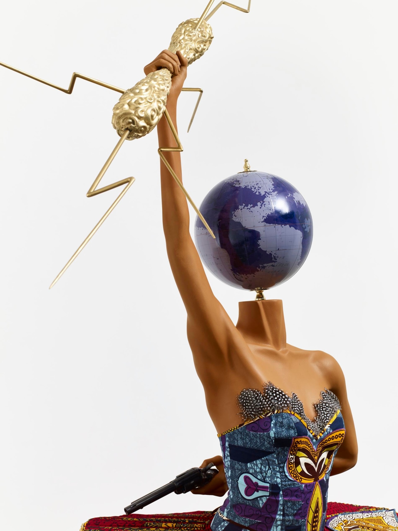 close up of a mannequin with a globe for a head holding a lightning bolt and a gun behind her back whilst also dancing ballet