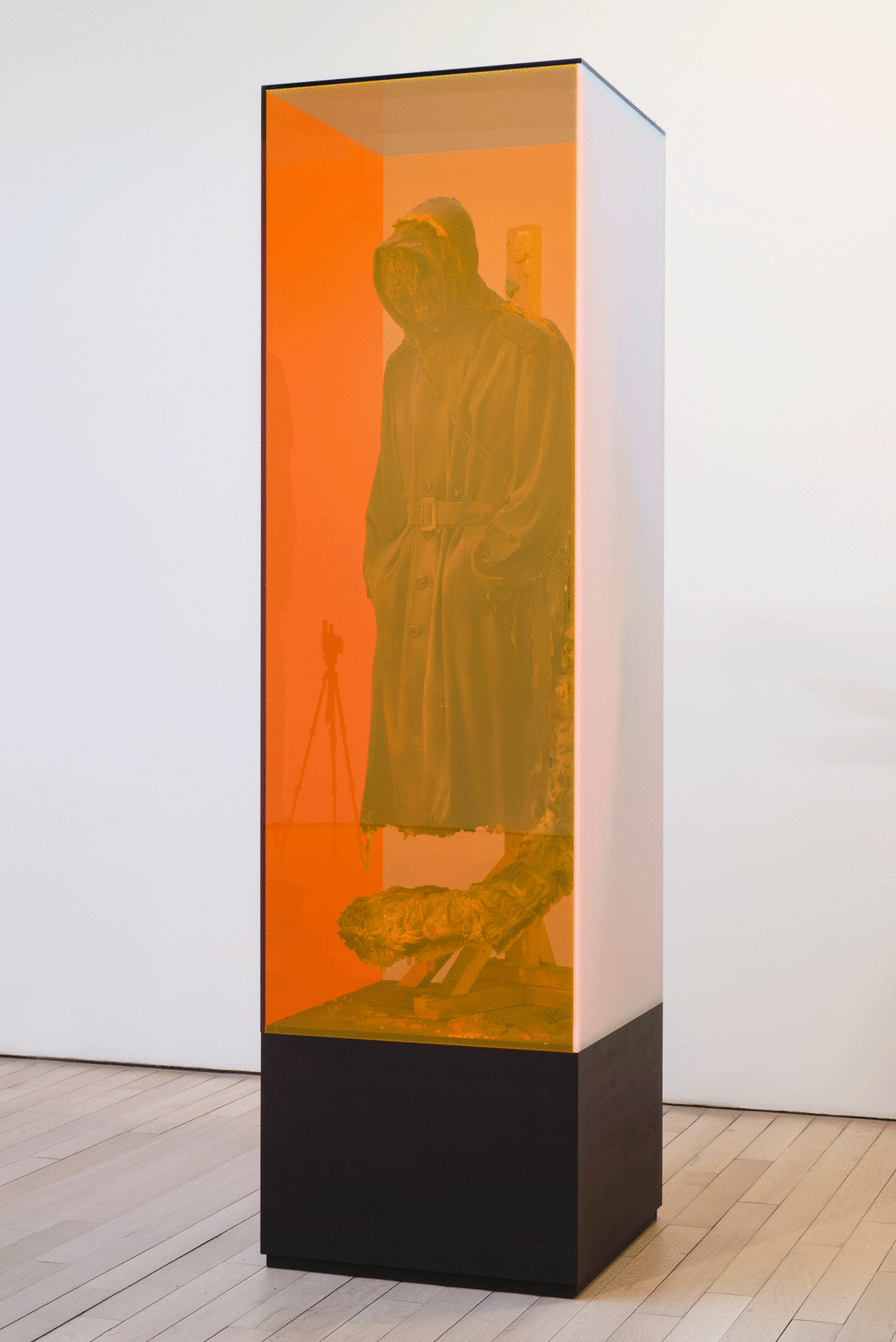 sculpture of floating hooded figure encased in yellow glass