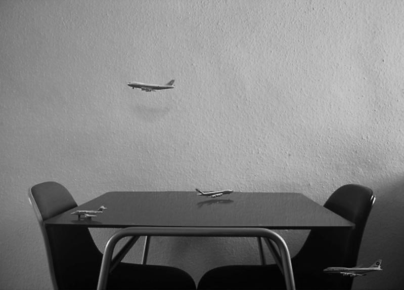 miniature airplanes flying around and landing on a small dining room table