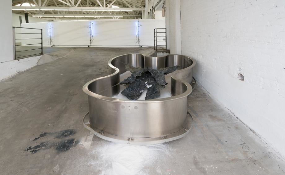 Metaphor, 2016 (pictured) comprises a stainless steel hydrotherapy tub filled with white sand; atop sits a &lsquo;lead jacket&rsquo;, made from sheets of solid lead and steel wire